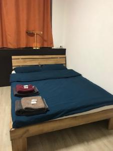 Una cama con una manta azul y una lámpara. en HéberGement du POD en La Chaux-de-Fonds