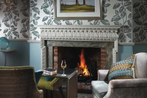a fireplace in a living room with a fire place at Lainston House in Winchester