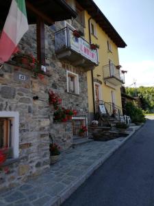 un edificio con flores a un lado. en Il Mulinel agriturismo en Teglio