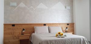 una camera con un letto bianco e 2 lampade di Il Mulinel agriturismo a Teglio