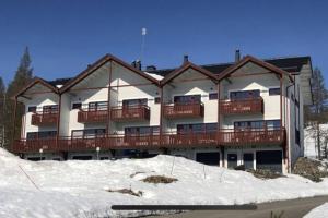 a large apartment building with a balcony in the snow at Ylläs with a view in Ylläsjärvi
