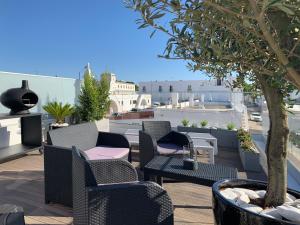 een patio met stoelen en een boom op een dak bij CasaBlanca - Haus am Meer in Fuzeta