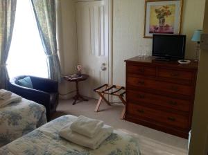 a bedroom with a bed and a dresser with a television at Yacht Bay View in Morecambe