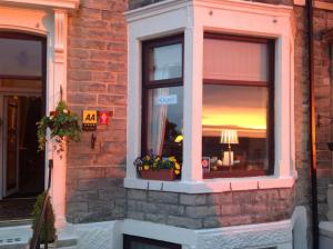 Una ventana de un edificio con flores. en Yacht Bay View, en Morecambe