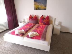 um quarto com uma cama grande e almofadas vermelhas em Gästehaus Bausch em Mehring
