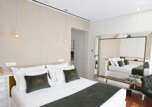 een hotelkamer met 2 bedden en een spiegel bij GuimaGold in Guimarães