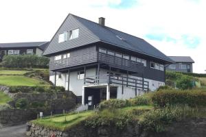 a large house on top of a hill at FaroeGuide seaview villa and apartment in Tórshavn