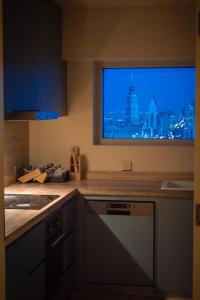 a kitchen with a window with a view of a city at fendi apartment in Riyadh