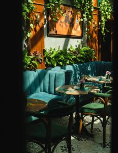 un restaurant avec des tables, des chaises et des plantes dans l'établissement Hotel Epidamn Boutique & Spa, à Durrës