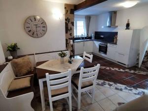 una cocina con mesa y sillas y un reloj en la pared en Mainschleifenherz, en Volkach