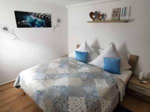 a bedroom with a bed with a blue and white quilt at Mainschleifenherz in Volkach