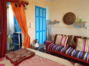 Rural Guest House فندق البيت الريفي في طنطا: غرفة معيشة مع أريكة وأبواب زرقاء