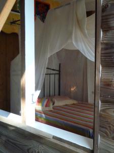 a bedroom with a bed in a window at Les jardins de Cousinière in Vieux-Habitants