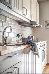 a kitchen with white cabinets and a sink at Egen lägenhet underbara Käringön möjlighet till parkeringsplats in Käringön