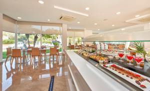 a buffet line with food on display in a restaurant at Globales Cala Bona in Cala Bona