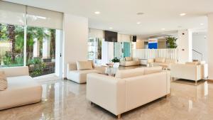 a living room with white furniture and large windows at Globales Cala Bona in Cala Bona