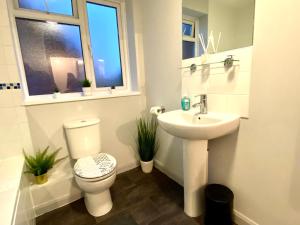 a bathroom with a toilet and a sink and a window at Funky Stylish Apartment! - 5 Minute Walk to the Best Beach! - Great Location - Parking - Fast WiFi - Smart TV - Newly decorated - sleeps up to 4! Close to Bournemouth & Poole Town Centre & Sandbanks in Bournemouth