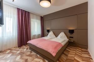 um quarto com uma cama com um cobertor rosa em Villa Elisa em Salzburgo