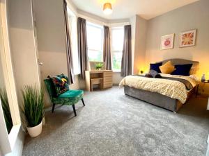 a bedroom with a bed and a chair at Funky Stylish Apartment! - 5 Minute Walk to the Best Beach! - Great Location - Parking - Fast WiFi - Smart TV - Newly decorated - sleeps up to 4! Close to Bournemouth & Poole Town Centre & Sandbanks in Bournemouth