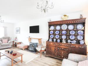 a living room with a large cabinet with plates on it at Bryn Afon Farm in Caernarfon
