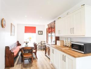 a kitchen with a table and a microwave at Bryn Afon Farm in Caernarfon