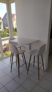 a white table and two chairs in a room with a window at 4* Ferienwohnung Neukirchen im Erzgebirge in Adorf