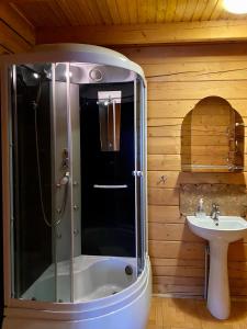 a bathroom with a shower and a sink at Villa PidStromom in Mykulychyn