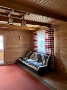 a bed in a room in a log cabin at Villa PidStromom in Mykulychyn