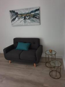 a black couch in a living room with a painting at Woodstock Studio Apartments in Cape Town