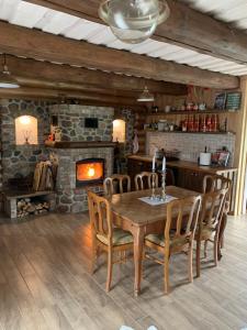 a dining room with a wooden table and a fireplace at Koka Pässä küla Võru vald in Võru