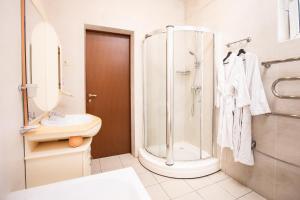 uma casa de banho com um chuveiro, um WC e um lavatório. em Almira Orion Group Hotel em Adler
