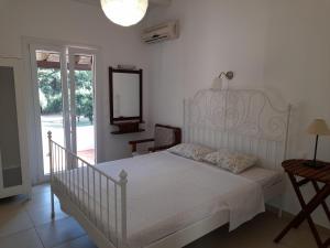 1 dormitorio con cama blanca y espejo en Lemontree Apartments, en Kassiopi