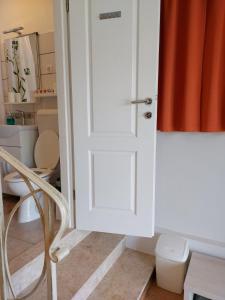 baño con puerta blanca y aseo en Soba Gracijela en Motovun