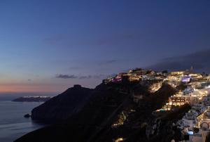 a view of a town on a mountain at night at Villa Bordeaux in Fira