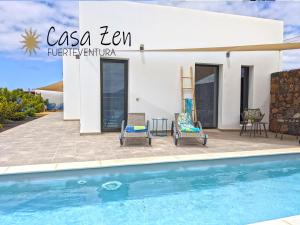 eine Villa mit einem Pool und einem Haus in der Unterkunft Casa Zen, design, swimming-pool, fibre-internet in Lajares