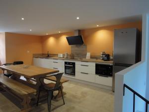 eine Küche mit einem Holztisch und einem Kühlschrank in der Unterkunft La Bourgade in Céreste