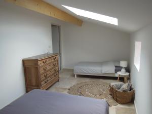 een slaapkamer met een bed en een dressoir bij La Bourgade in Céreste