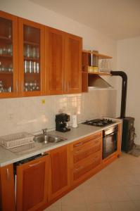 una cocina con armarios de madera y fregadero en Apartment Vukorep en Suđurađ