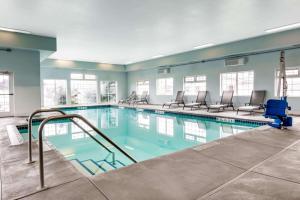 a large swimming pool with chairs in a building at Super 8 by Wyndham Spokane Valley in Spokane Valley