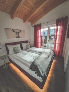 - une chambre avec un grand lit et des rideaux rouges dans l'établissement Hochalmbahnen Chalets Rauris 1-02, Maislaufeldweg 1b, à Rauris