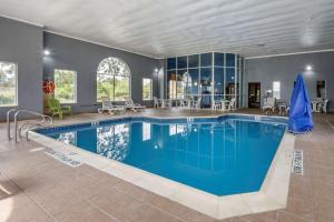 a large swimming pool with blue water in a house at Comfort Inn Meadowlands in Washington