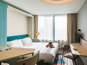 a living room filled with furniture and a window at Aparthotel Adagio London Stratford in London