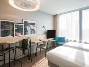 a hotel room with a bed and a desk with a computer at Aparthotel Adagio London Stratford in London