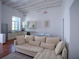 a living room with a white couch and a kitchen at Retreat Paros - The Loft Apartment in Parikia