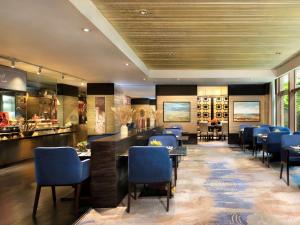 a restaurant with blue chairs and tables and a bar at Fairmont Beijing in Beijing