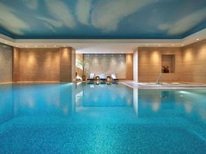 a swimming pool in a hotel with blue water at Fairmont Beijing in Beijing