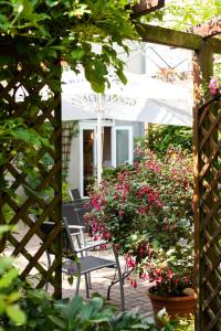 a patio with chairs and flowers in a garden at Hotel Garni Schlossgarten in Neustrelitz