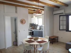a kitchen and dining room with a table and chairs at TERRA LEMNIA in Moúdhros