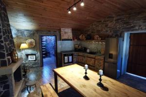 uma cozinha com uma mesa de madeira e um frigorífico em Casa do Linho 400 year old country cottage em Oleiros