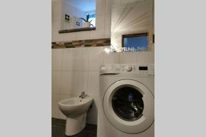 un bagno con lavatrice e lavandino di Casa do Linho 400 year old country cottage a Oleiros
